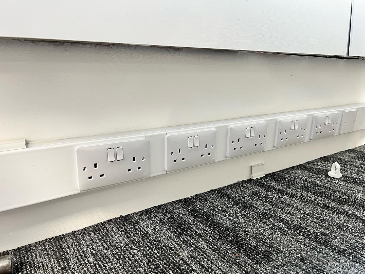 Row of double sockets along an office skirting board — Hager and Marshall Tufflex install